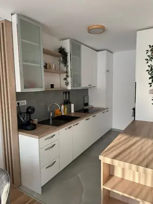 a kitchen with white cabinets and a sink at City Apartment in Banja Luka
