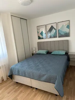 a bedroom with a bed with three pictures on the wall at City Apartment in Banja Luka