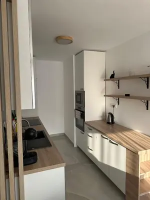 a kitchen with white cabinets and a counter top at City Apartment in Banja Luka
