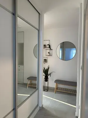 a hallway with a mirror and a bench at City Apartment in Banja Luka