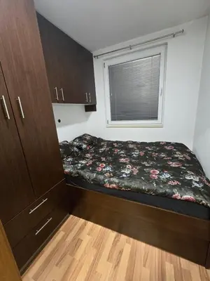 a small bedroom with a bed and a window at Apartman Manjić in Doboj
