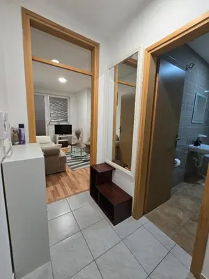a kitchen with a refrigerator and a living room at Apartman Manjić in Doboj