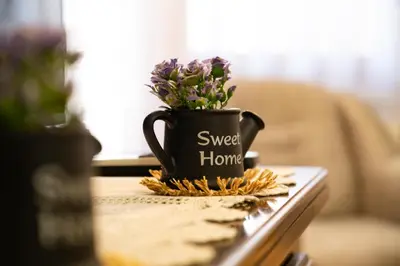 a black coffee cup with purple flowers on a table at Gradina Stan na Dan in Doboj