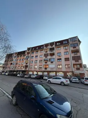 a blue car parked in front of a large building at Gradina Stan na Dan in Doboj