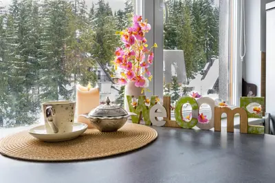 a table with a coffee cup and a sign that reads mom at Apartman Bn Vlasic in Vlasic
