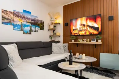 a living room with a couch and a fire painting on the wall at Apartman Bn Vlasic in Vlasic