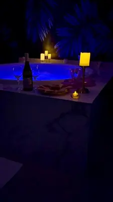 a table with a bottle of wine and two glasses at Kalipso spa apartman sa jakuzzijem in Doboj