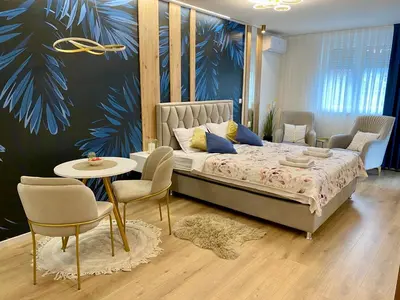 a bedroom with a bed and a table and chairs at Kalipso spa apartman sa jakuzzijem in Doboj