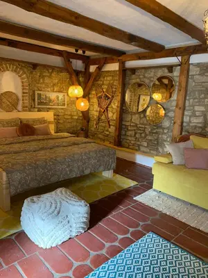 a bedroom with a bed and a stone wall at Sokograd Royal in Šipovo
