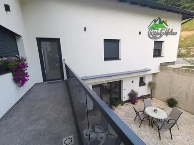 a balcony of a building with a table and chairs at Rajske doline in Oćune