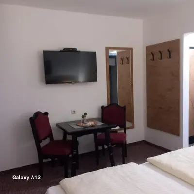 a room with a table and two chairs and a television at Rajske doline in Oćune