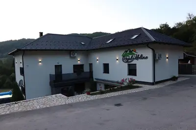 a white building with a sign on it at Rajske doline in Oćune