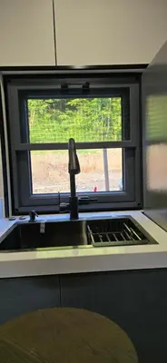 a kitchen with a sink and a window at APPLE Cabin with Jacuzzi - Sauna in Drenova Glavica