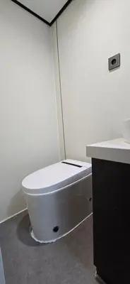 a white bathroom with a toilet and a sink at APPLE Cabin with Jacuzzi - Sauna in Drenova Glavica