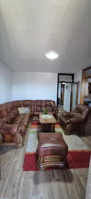 a living room with a leather couch and a table at Center Heritage Two-bedroom Apartment in Teslić