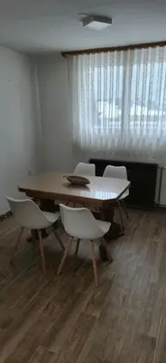 a dining room with a table and white chairs at Center Heritage Two-bedroom Apartment in Teslić