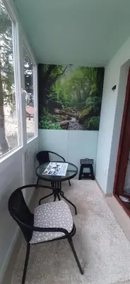 a table and chairs in a room with a painting on the wall at Apartman Pinja in Vlasic