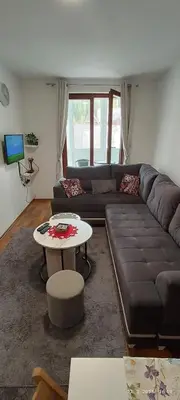 a living room with a couch and a table at Apartman Pinja in Vlasic