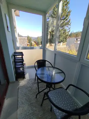 a room with two chairs and a table and two windows at Apartman Pinja in Vlasic