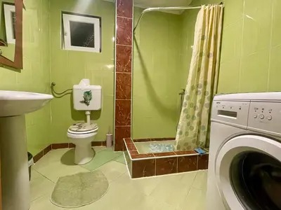 a green bathroom with a toilet and a shower at Apartman Iman in Kulen Vakuf