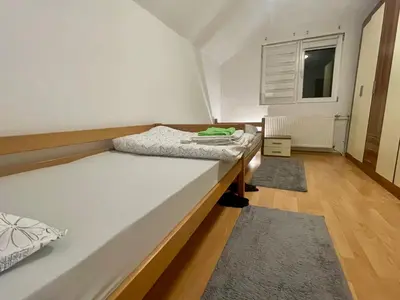 a small bedroom with a bed and a window at Apartman Iman in Kulen Vakuf