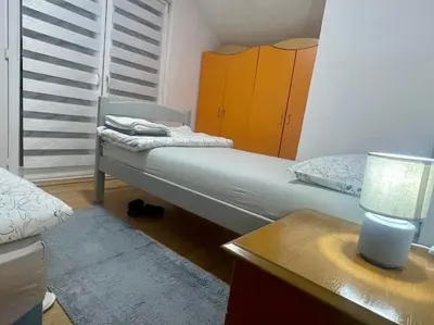 a small bedroom with a bed and a dresser at Apartman Iman in Kulen Vakuf
