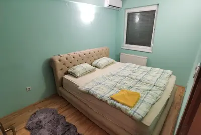 a bed with a blanket and pillows in a room at Apartman Urban Rest in Doboj