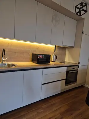 a kitchen with white cabinets and a sink at Apartment Modern Nest in Zenica