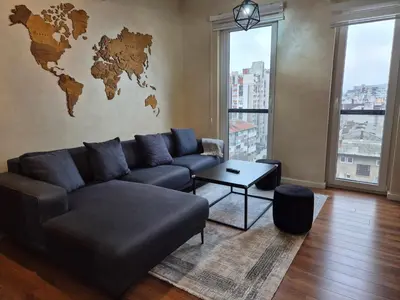 a living room with a couch and a world map on the wall at Apartment Modern Nest in Zenica