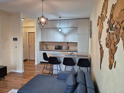 a kitchen and living room with a table and chairs at Apartment Modern Nest in Zenica