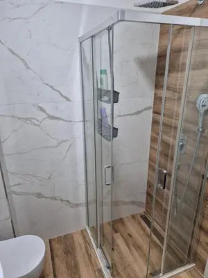 a shower with a glass door in a bathroom at Apartment Modern Nest in Zenica