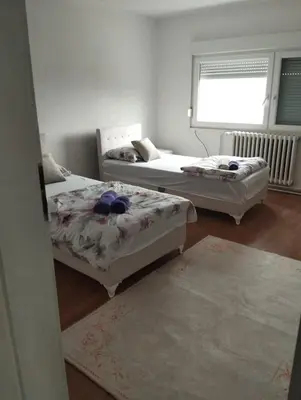 a room with three beds and a window at apartman Sara in Tuzla