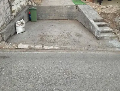 a cat sitting on the side of a street at apartman Sara in Tuzla