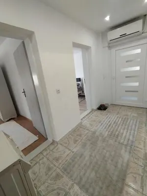 a living room with white walls and a door at apartman Sara in Tuzla