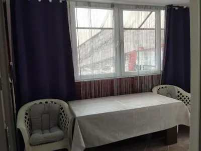 a bed in a room with two chairs and a window at apartman Sara in Tuzla