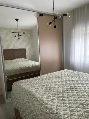 a bedroom with two beds and a mirror at Studio in Modriča
