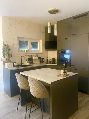 a kitchen with a large island with stools in it at Studio in Modriča
