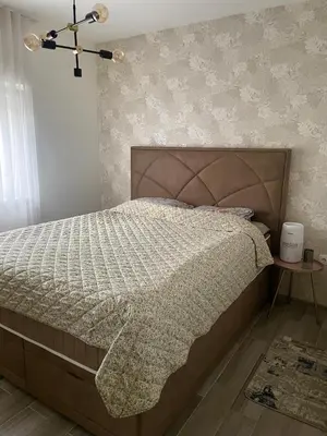 a bedroom with a bed with a comforter at Studio in Modriča