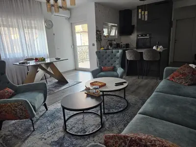 a living room with blue couches and a table at Studio in Modriča