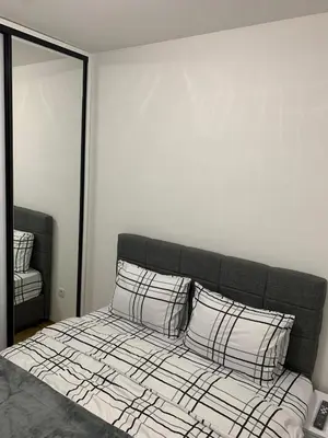 a bedroom with a bed with two pillows at Zlatni San apartman 3 in Banja Luka