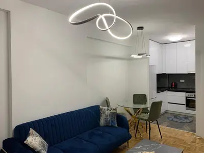 a living room with a blue couch and a table at Zlatni San apartman 3 in Banja Luka
