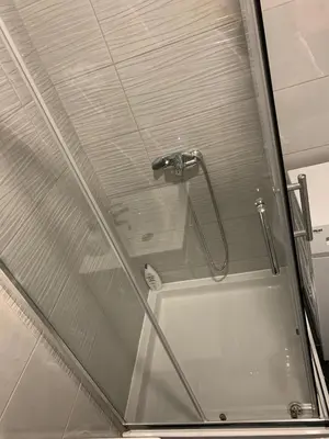 a glass shower door with a shower head in a bathroom at Zlatni San apartman 3 in Banja Luka