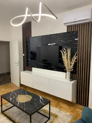 a living room with a large tv on a white entertainment center at Zlatni San apartman 3 in Banja Luka