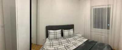 a bedroom with a bed in a room with a window at Zlatni San apartman 3 in Banja Luka