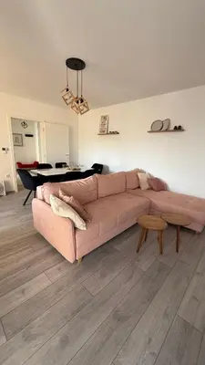 a living room with a pink couch and a table at Apartman Vrućica view in Teslić