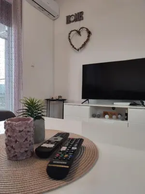 a living room with two remote controls and a tv at Apartman Sedra in Bihać