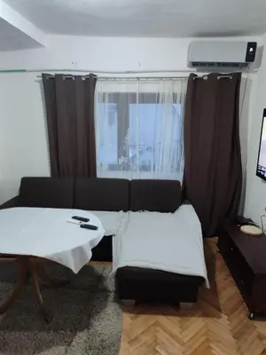 a living room with a black couch and a window at Apartman Luna in Vrbanja