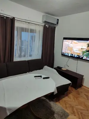 a living room with a couch and a flat screen tv at Apartman Luna in Vrbanja