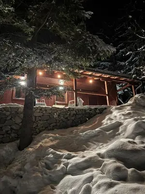 a log cabin with snow in front of it at night at Mountain Mia in Šišava