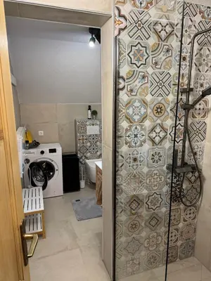 a bathroom with a shower with a tile wall at Mountain Mia in Šišava